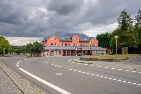 Budova Hotelu Hukvaldy s červenou fasádou v centru obce Hukvaldy