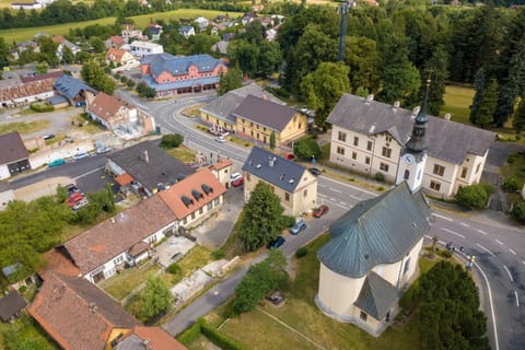 Letecký pohled na obec Hukvaldy s kostelem a hotelem